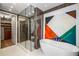 Stylish bathroom boasts a glass shower, soaking tub, and artistic geometric wall decor at 2233 Peachtree Ne Rd # 1207, Atlanta, GA 30309