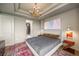 Comfortable bedroom features modern chandelier, large artwork, and doorway to walk-in closet at 2233 Peachtree Ne Rd # 1207, Atlanta, GA 30309