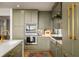 Close up of a modern kitchen with stainless steel appliances, marble countertops, and custom green cabinets at 2233 Peachtree Ne Rd # 1207, Atlanta, GA 30309