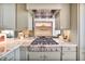 Close up of a gourmet kitchen with stainless steel gas range and elegant backsplash at 2233 Peachtree Ne Rd # 1207, Atlanta, GA 30309