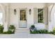 Welcoming home entrance with stylish lanterns, shutters and lush landscaping with blue flowers at 3489 Knollwood Nw Dr, Atlanta, GA 30305