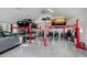 Spacious garage interior with red car lifts, multiple cars and motorcycles, and ample storage at 3489 Knollwood Nw Dr, Atlanta, GA 30305