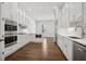 Open concept kitchen with white cabinets, double ovens, and hardwood floors at 3707 Peachtree Ne Rd # 8, Atlanta, GA 30319