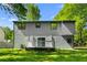 View of the home's siding and backyard with a small white deck and green lawn at 6703 Cameron Rd, Morrow, GA 30260