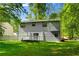 Spacious backyard featuring a small white deck, surrounded by lush greenery and trees at 6703 Cameron Rd, Morrow, GA 30260