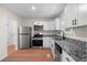 Bright kitchen with stainless steel appliances, granite countertops, and new white cabinets at 6703 Cameron Rd, Morrow, GA 30260
