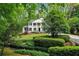 Beautiful two-story home with black shutters, white columns, and lush green landscaping at 2562 Red Valley Rd, Atlanta, GA 30305