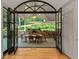 Covered outdoor dining area with a stone fireplace and view of the landscaped yard at 2562 Red Valley Rd, Atlanta, GA 30305