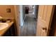 Hallway looking into a bathroom with a cream color vanity at 4175 Round Stone Dr, Snellville, GA 30039