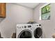 Convenient laundry room with modern front-loading washer and dryer, and a bright window at 230 Summerfield Dr, Alpharetta, GA 30022
