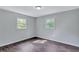 Empty bedroom featuring hardwood floors, two windows offering natural light, and neutral paint throughout at 3795 Willowbrook Dr, Douglasville, GA 30135