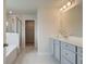 Bright bathroom featuring a double vanity, a soaking tub, and a glass-enclosed shower at 540 Teversham Dr, Mcdonough, GA 30253