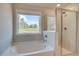 Bathroom featuring a garden tub, shower, and large windows with nature views at 540 Teversham Dr, Mcdonough, GA 30253