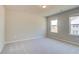 Bright bedroom with neutral walls and carpet and a view of the neighborhood through two windows at 540 Teversham Dr, Mcdonough, GA 30253