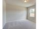 Comfortable bedroom with neutral tones, soft carpet, and a window view of the outdoors at 540 Teversham Dr, Mcdonough, GA 30253