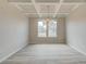 Bright dining room featuring a coffered ceiling, wood floors, and a stylish chandelier at 540 Teversham Dr, Mcdonough, GA 30253
