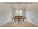 Elegant dining room featuring a coffered ceiling, modern chandelier, and sleek hardwood floors at 540 Teversham Dr, Mcdonough, GA 30253