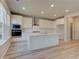 Modern kitchen featuring white cabinets, stainless steel appliances, and a large center island with a sink at 540 Teversham Dr, Mcdonough, GA 30253