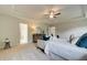Elegant main bedroom with tray ceiling, neutral colors, plush carpet, and a sitting area for relaxation at 540 Teversham Dr, Mcdonough, GA 30253