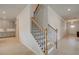 Modern staircase with wooden handrail and iron balusters next to the entry and kitchen at 540 Teversham Dr, Mcdonough, GA 30253