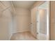 A walk-in closet with neutral carpeting and white shelving, connected to an adjacent room at 540 Teversham Dr, Mcdonough, GA 30253