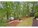Lush backyard with stone steps leading to the lake, mature trees, and manicured landscaping at 960 Tiverton Ln, Alpharetta, GA 30022