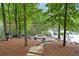 Backyard area with a stone fire pit for outdoor gatherings by the serene lake at 960 Tiverton Ln, Alpharetta, GA 30022