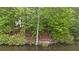 Lakeside backyard featuring a stone fire pit and wooded scenery at 960 Tiverton Ln, Alpharetta, GA 30022