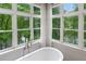 Close-up of bathroom soaking tub with views of the surrounding woods at 960 Tiverton Ln, Alpharetta, GA 30022