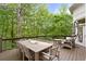 A spacious outdoor deck features a dining area and cushioned seating, perfect for enjoying the serene, wooded backdrop at 960 Tiverton Ln, Alpharetta, GA 30022