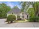 Elegant home featuring manicured landscaping, a circular driveway, and arched windows at 960 Tiverton Ln, Alpharetta, GA 30022