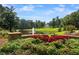 Beautiful view of a pond with a fountain surrounded by flowers and a large house at 960 Tiverton Ln, Alpharetta, GA 30022