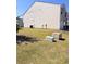 The backyard features a grassy area and the side of the house that is tan with a vinyl siding at 2089 Belmont Cir, Conyers, GA 30012