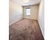 Simple bedroom with neutral walls, carpet flooring, and a window with blinds for natural light at 2089 Belmont Cir, Conyers, GA 30012