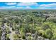 Scenic aerial of a wooded community with a lake and beautiful homes beneath a partly cloudy sky at 3918 Windgrove Xing, Suwanee, GA 30024
