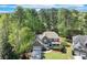 A lovely home surrounded by mature trees boasts a manicured lawn and charming curb appeal in this aerial view at 3918 Windgrove Xing, Suwanee, GA 30024
