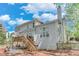 The back of the house features a spacious deck with stairs to a brick patio and lush tree views at 3918 Windgrove Xing, Suwanee, GA 30024
