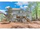 Back of a light gray two-story home with a wood deck and patio, set in a private backyard with trees at 3918 Windgrove Xing, Suwanee, GA 30024