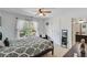 Bright bedroom with ceiling fan, window with curtains, and doorway to the en-suite bathroom at 3918 Windgrove Xing, Suwanee, GA 30024