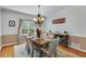 Elegant dining room with a chandelier, wood floors, and a view of the backyard at 3918 Windgrove Xing, Suwanee, GA 30024