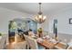 Inviting dining room features hardwood floors, elegant chandelier, and open access to the adjacent living area at 3918 Windgrove Xing, Suwanee, GA 30024