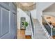 Elegant foyer with a grand staircase, hardwood floors, and stylish decor at 3918 Windgrove Xing, Suwanee, GA 30024