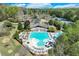 Aerial view showcasing a large community pool with water slides, surrounding lounge areas, and lush greenery at 3918 Windgrove Xing, Suwanee, GA 30024