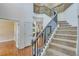 Bright foyer featuring a carpeted staircase with black iron spindles and grey wood handrail at 3918 Windgrove Xing, Suwanee, GA 30024