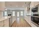 Bright kitchen showcases stainless appliances, white cabinets, and seamless flow to the living room at 576 Teversham Dr, Mcdonough, GA 30253