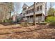 Two-story home featuring a backyard with a stone patio, a fire pit, and a wooded backdrop at 6236 Benbrooke Nw Dr, Acworth, GA 30101