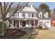 Inviting two-story home with a covered front porch and three-car garage, enhanced by mature trees at 6236 Benbrooke Nw Dr, Acworth, GA 30101