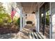 Welcoming front porch with brick flooring, a porch swing, and an American flag displaying patriotic charm at 6236 Benbrooke Nw Dr, Acworth, GA 30101