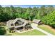 Beautiful home with detached garage, long driveway, green lawn and mature trees surrounding property at 105 Chantilly Ln, Fayetteville, GA 30215