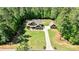 Expansive aerial view showcasing a two-story home with a long driveway and lush surroundings at 105 Chantilly Ln, Fayetteville, GA 30215